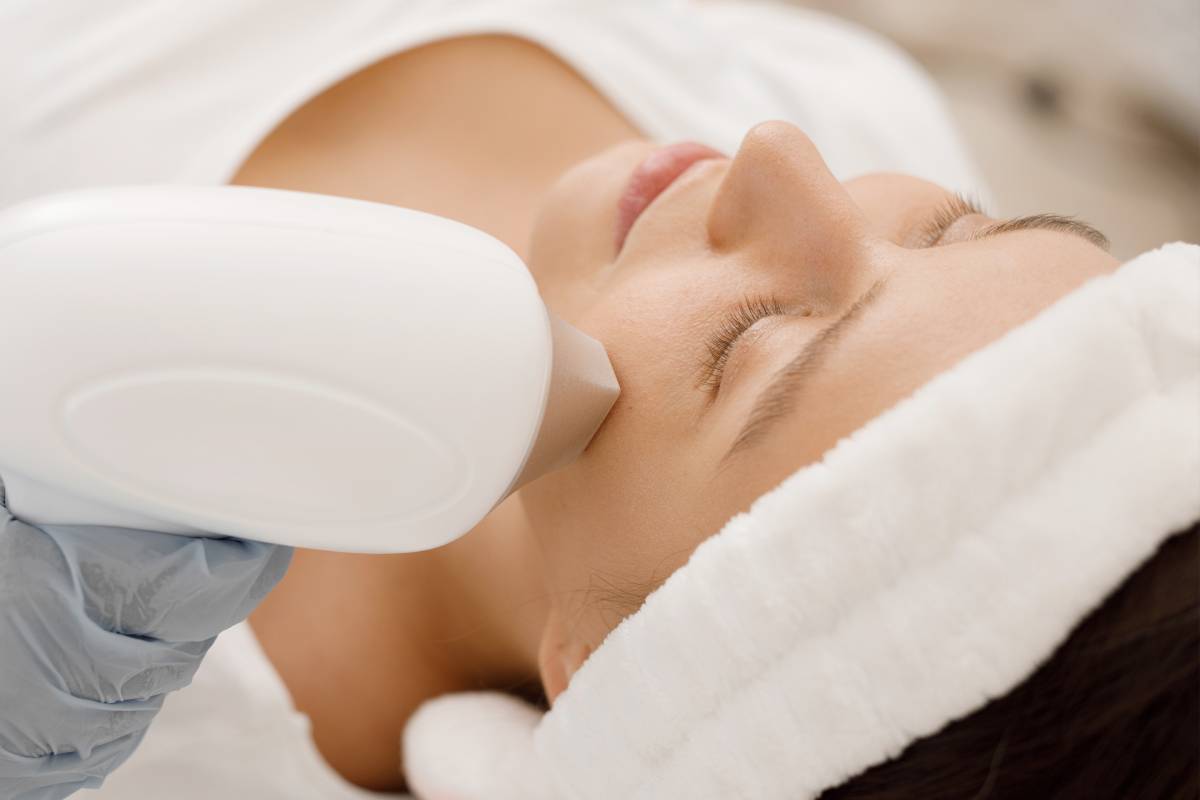 Young woman having laser hair removal procedure of face zone by specialist in cosmetic center. Removes pigmentation in cosmetic clinic. Intensive Pulsed Light Therapy. Anti-aging treatments.